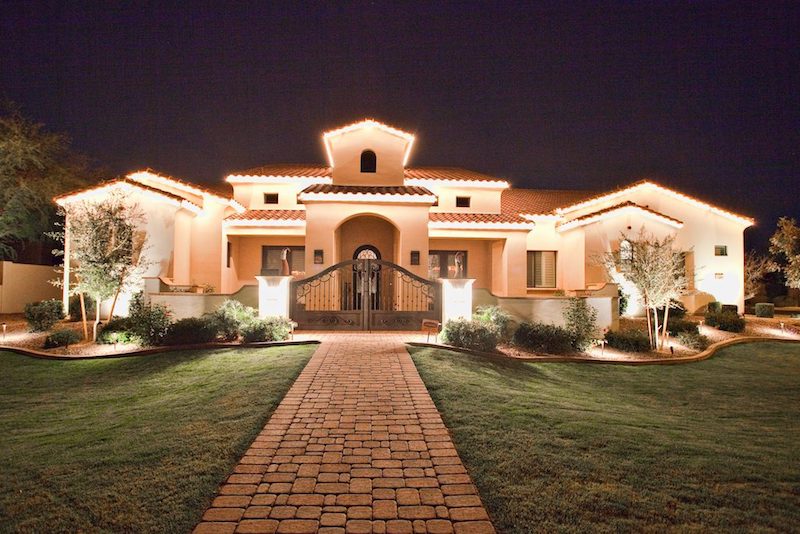 Professional Christmas light installation by Stay Off The Roof on a Paradise Valley, AZ estate — warm roofline lights and decorated trees at dusk