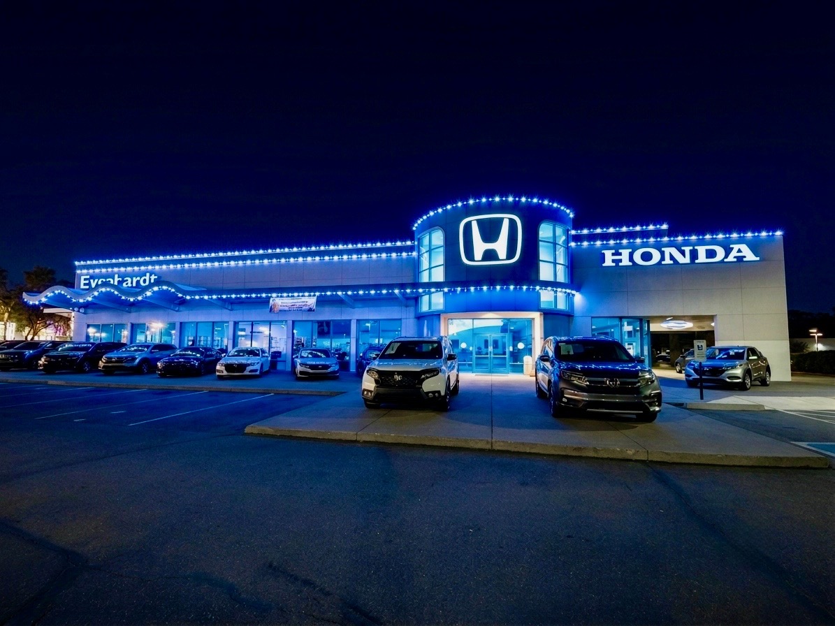Car dealership building outlined in commercial Christmas lights at night