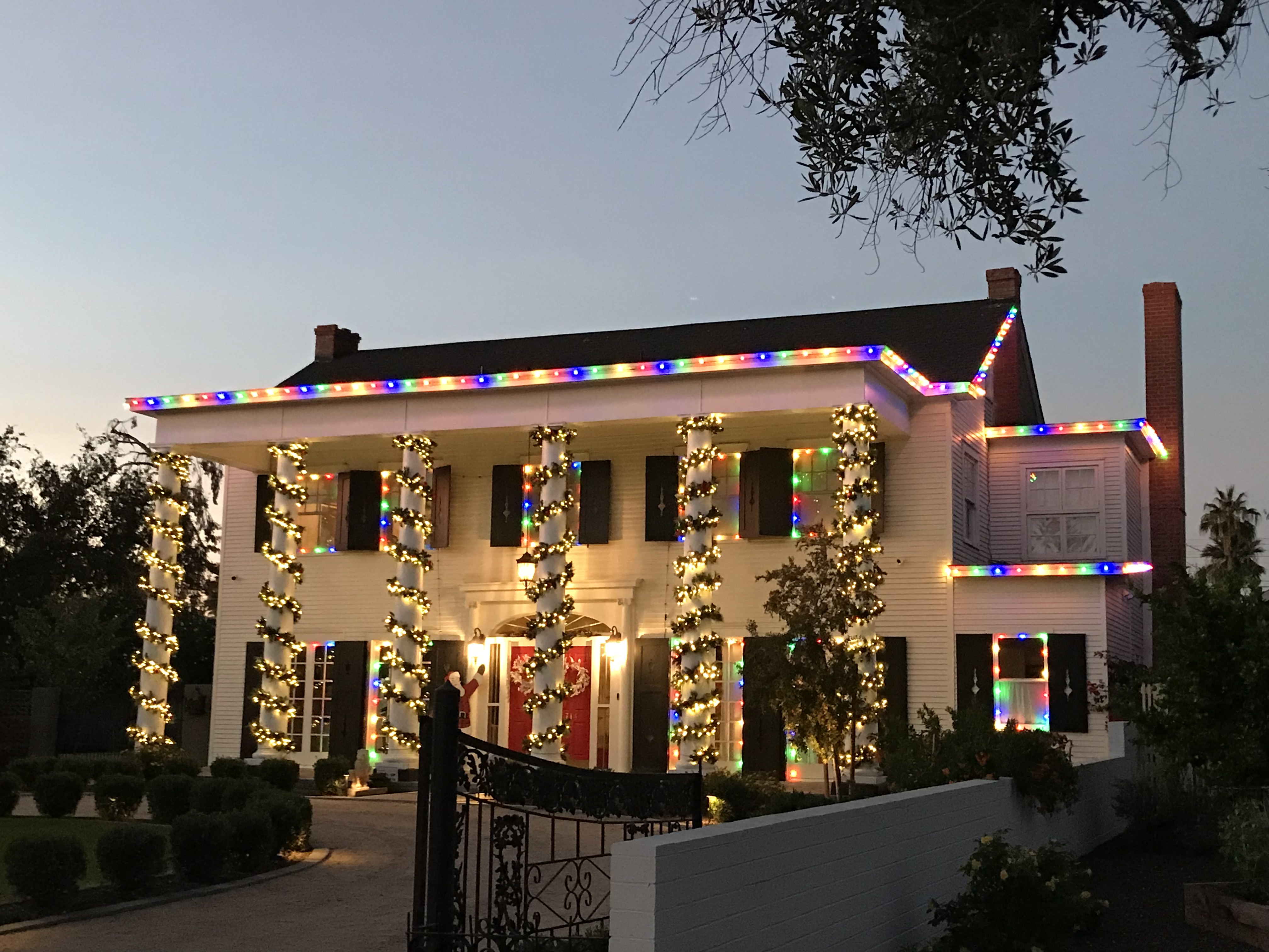 Phoenix colonial home decorated with professional Christmas lights at night