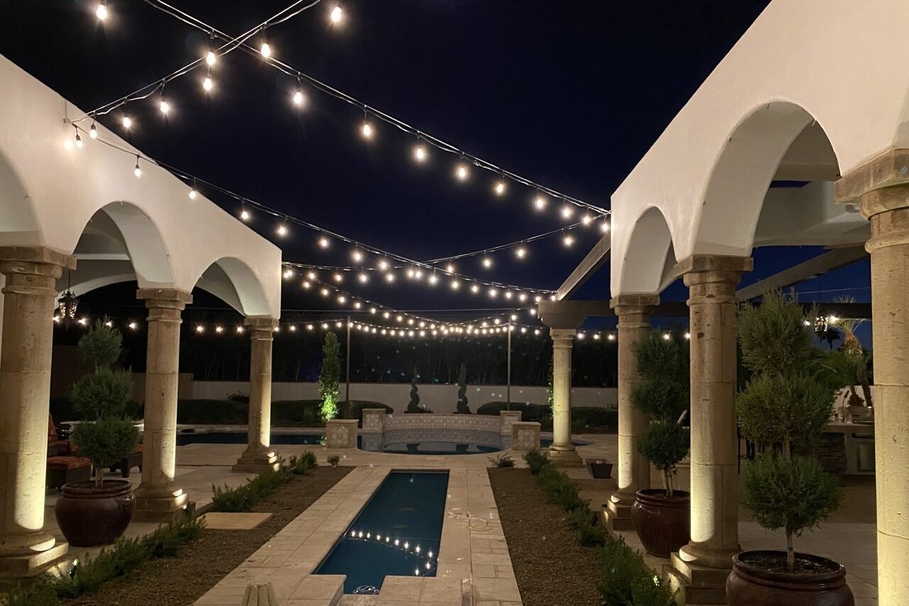 Phoenix courtyard patio glowing under warm bistro string lights at night
