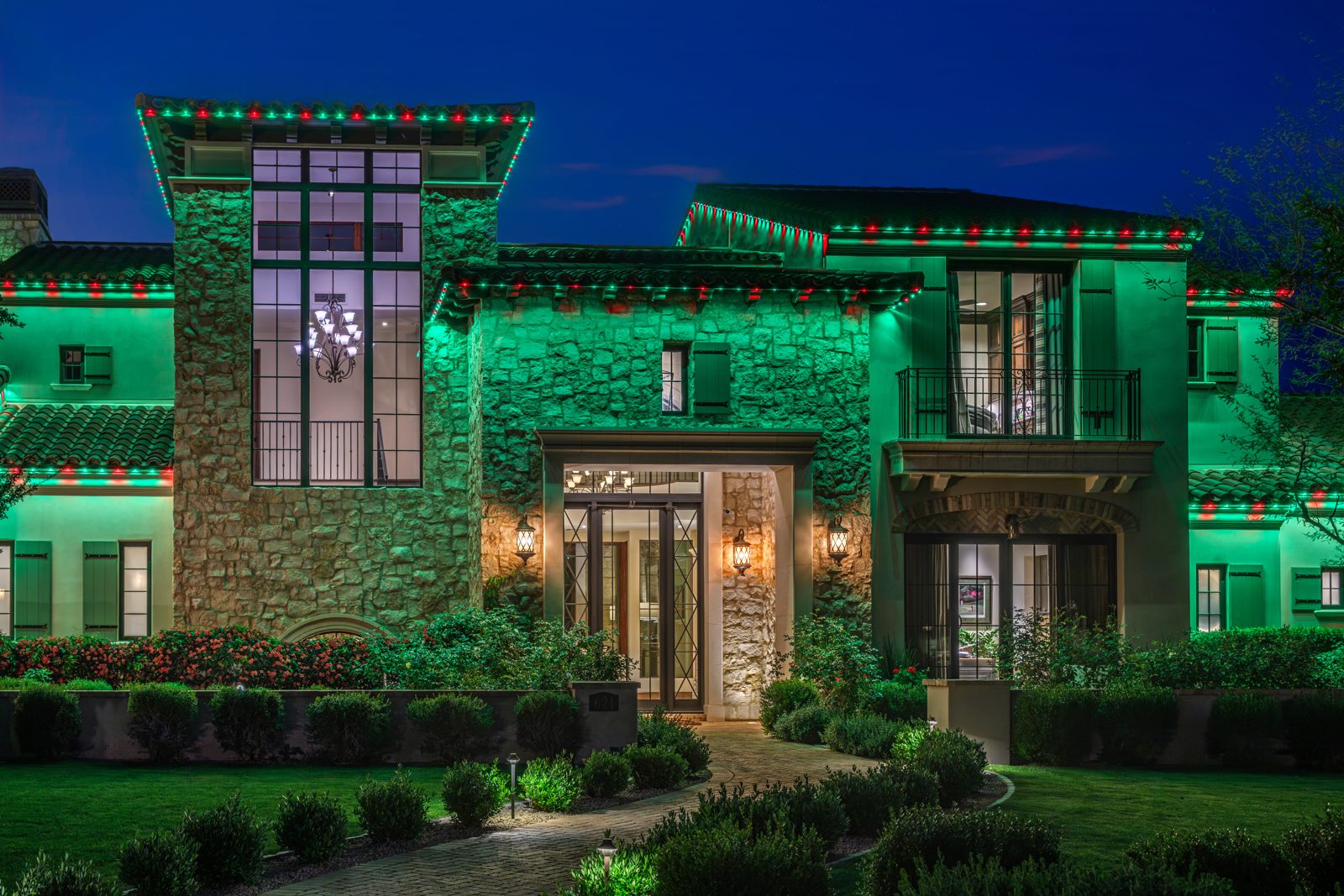 Red and green Gemstone permanent Christmas lights on a two-story East Valley estate with green wall wash